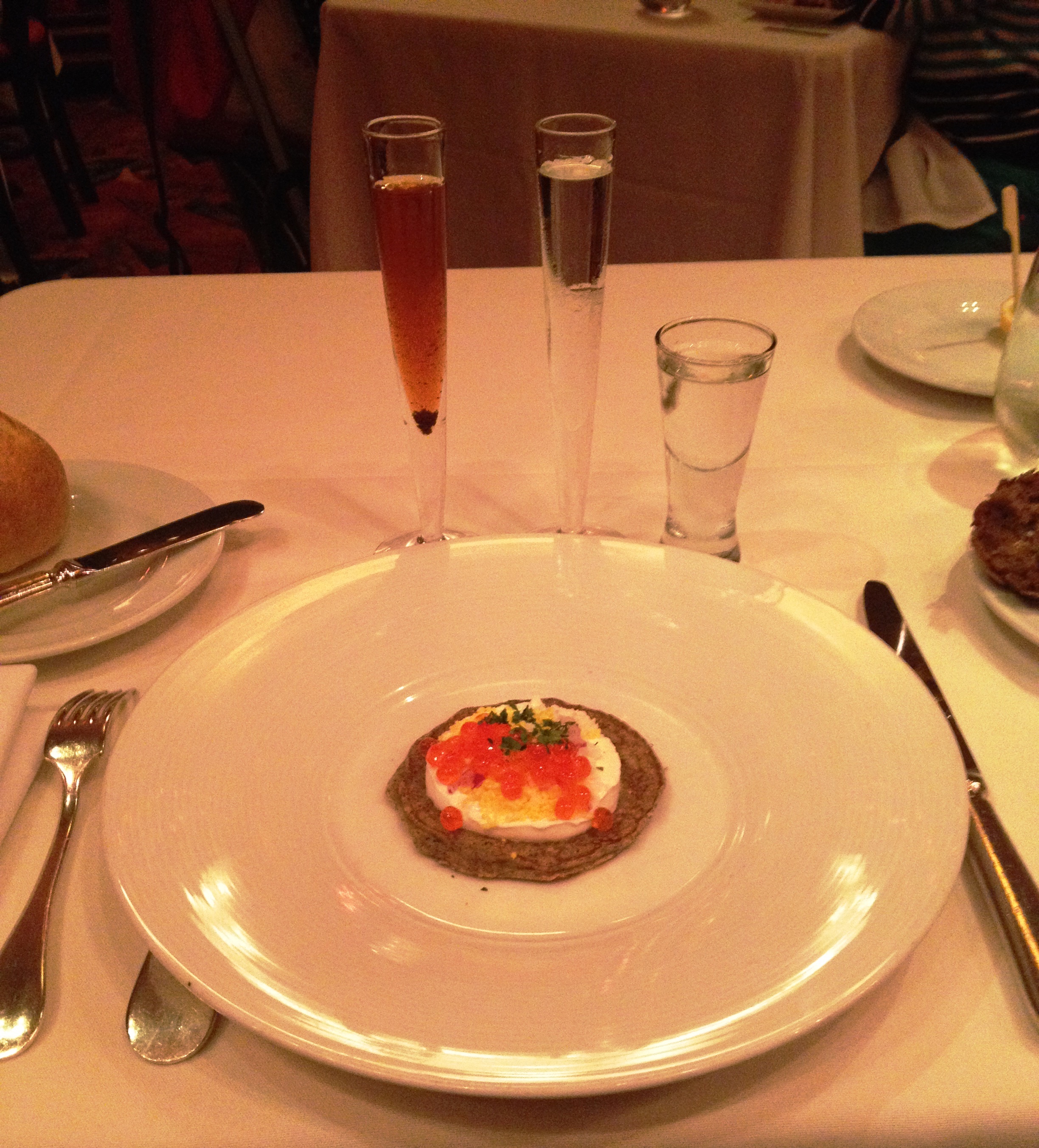 Blini topped with sour cream and trout, salmon and white fish roes
